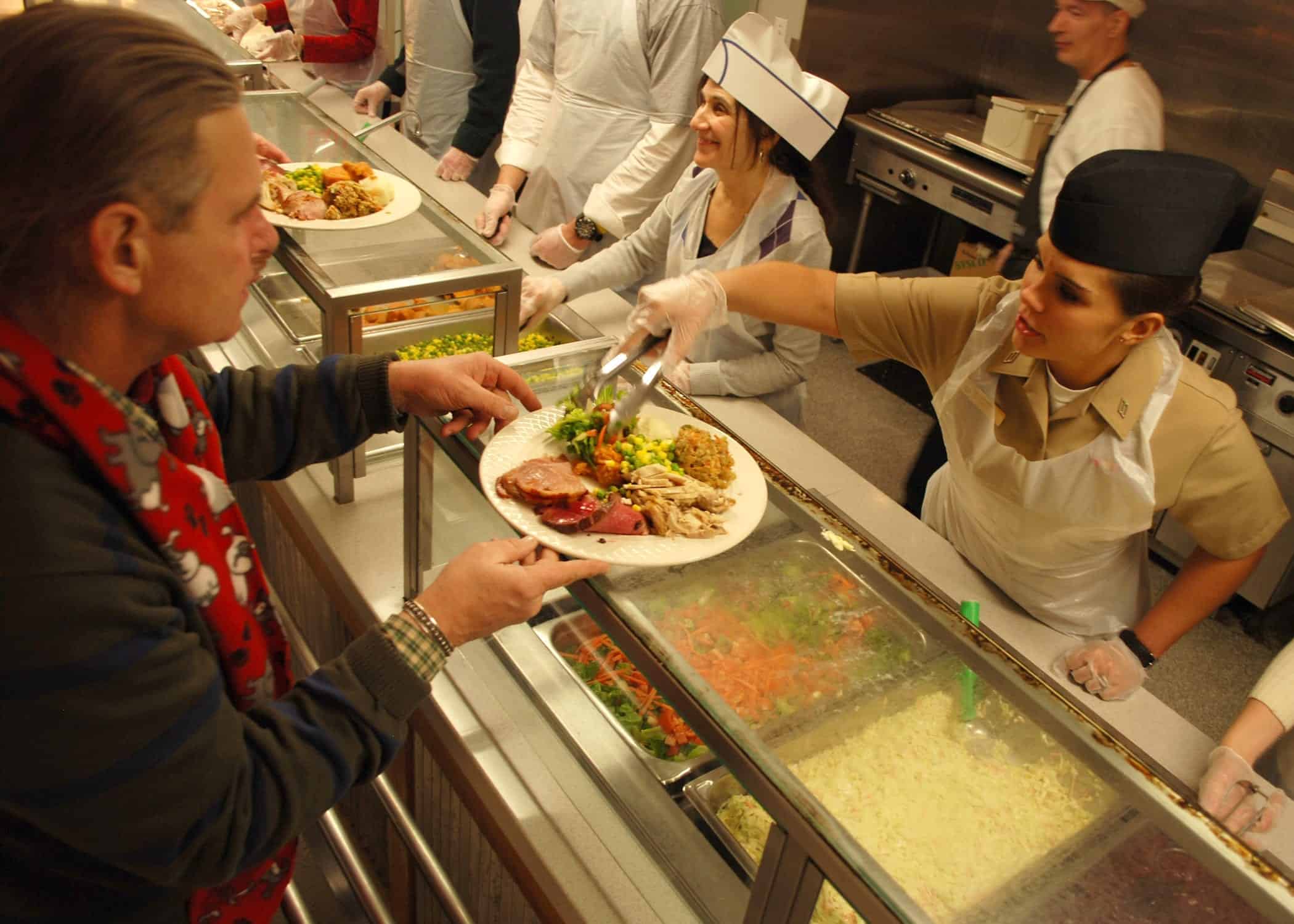 101225-N-7642M-082 BOSTON (Dec. 25, 2010) Gunner's Mate Seaman Kali Morris, assigned to USS Constitution, serves Christmas dinner at the New England Center for Homeless Veterans. Constitution Sailors have volunteered 1,113 man-hours to the center since establishing a partnership in April. (U.S. Navy photo by Mass Communication Specialist 3rd Class Kathryn E. Macdonald/Released)