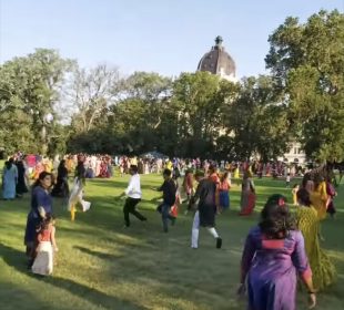 Participants of the Garba-Ras event dance on the greens in front of the Legislative Building.