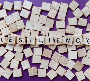 Scrabble letters spread out to form the word “resiliency”