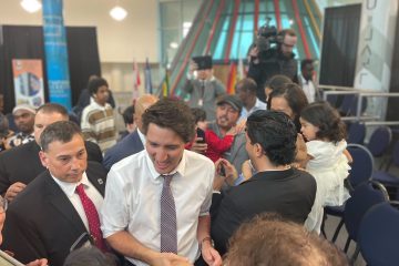 Justin Trudeau is swarmed by members of the town council as he makes his exit. 
